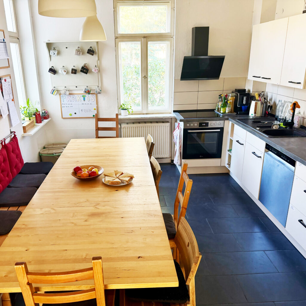 Freundlicher Wohnbereich mit offener Küche, Tisch und Stühlen