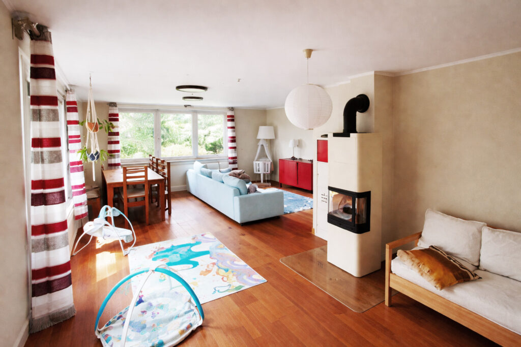 Freundlicher Wohnbereich mit Sofa, Tisch, Stühlen und Kamin